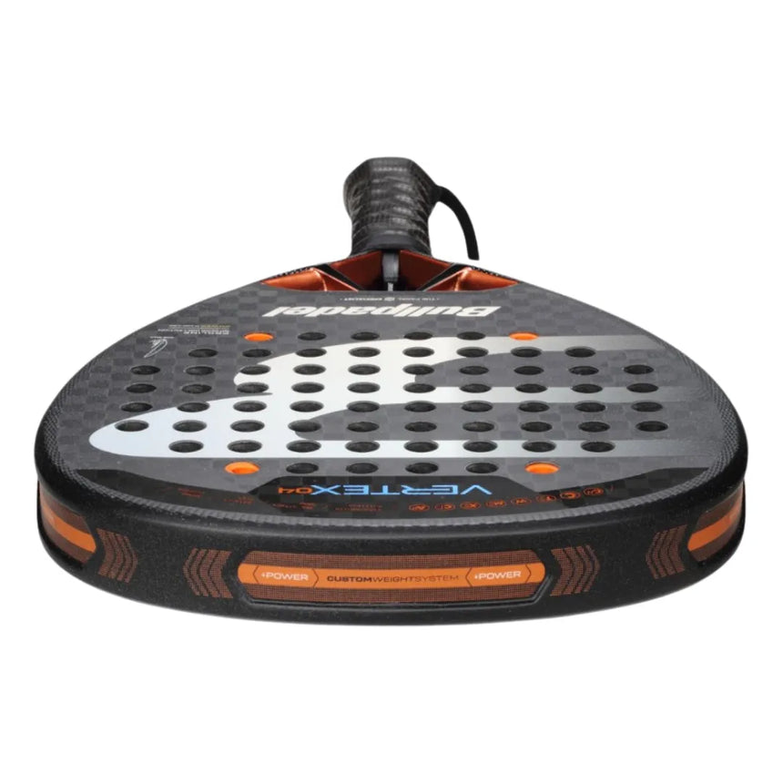 Close-up of the BULLPADEL RACKET VERTEX 04 2025 JUAN TELLO by Padel Smash Academy, like new. It features a black and orange design with a perforated face and wrist strap for total control. Dynamic patterns and branding complete its sleek look.