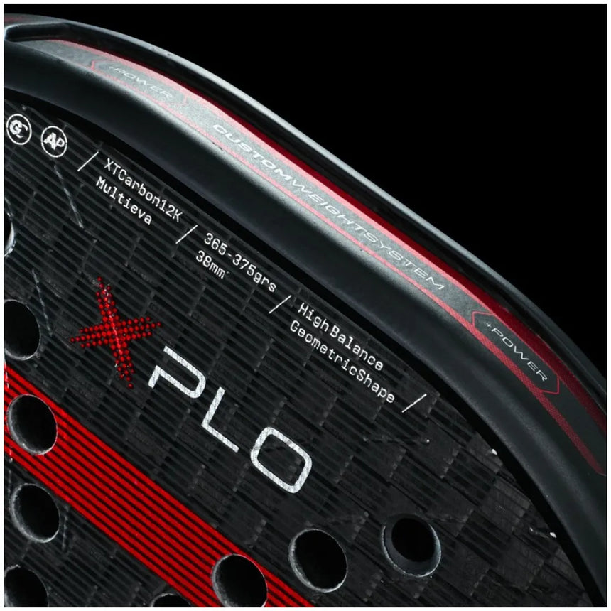 Close-up of a BULLPADEL RACKET XPLO 2025 MARTÍN DI NENNO from Padel Smash Academy against a black background. The racket has a sleek carbon fiber pattern with red and black hues, showcasing XPLO text and construction details in bold red accents throughout.