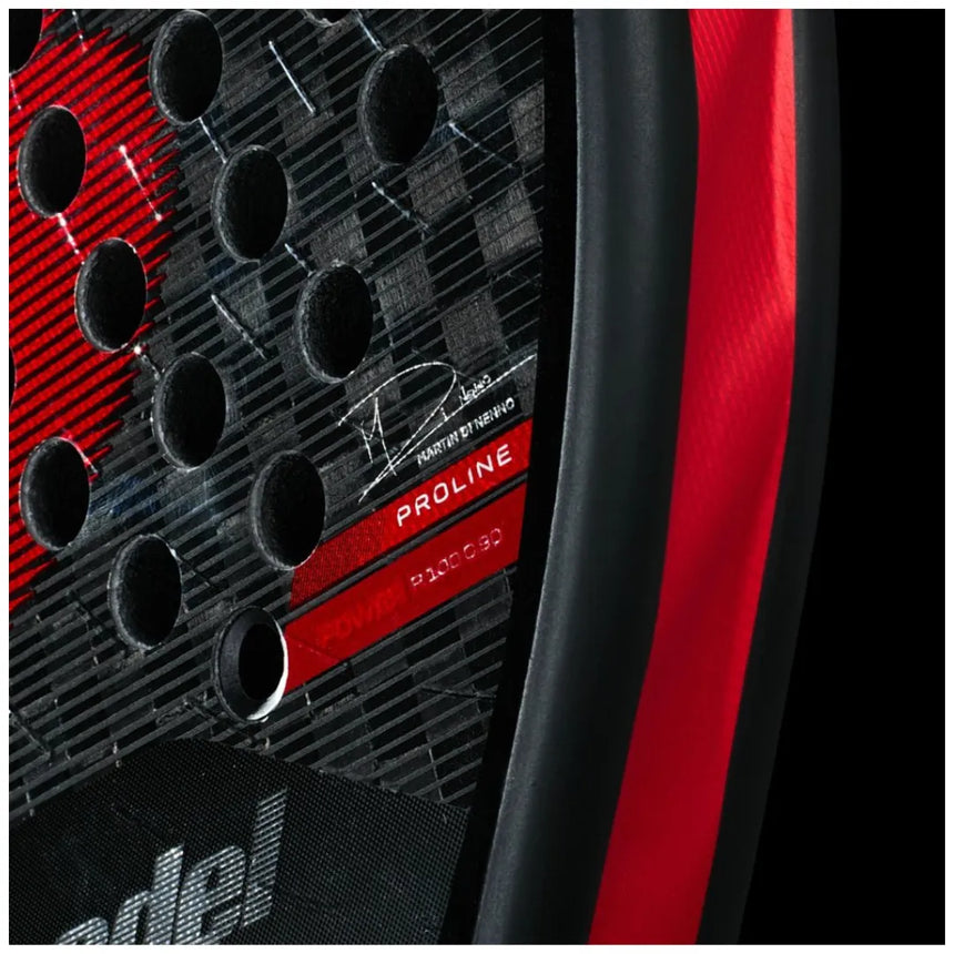 Close-up of a red and black Bullpadel racket by Padel Smash Academy with a carbon fiber texture. It has circular holes and Proline and X-POWER text. This glossy red BULLPADEL RACKET XPLO 2025 MARTÍN DI NENNO (LIKE NEW) captures the essence of XPLO performance.