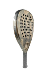 Close-up of the Cork Padel Extreme Black showcases its worn, textured surface. A creation by Cork Padel, it features multiple circular holes and a black handle with a patterned grip against a plain white background.
