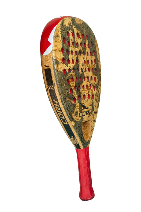 Close-up of the limited edition Cork Padel Extreme Red racket by Cork Padel featuring a red grip and worn brown surface with many small holes, along with black and white details and some visible text highlighting its advanced features.