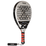 The NOX Padel Racket AT10 Genius 18K by 2024 Agustin Tapia features a sleek black and silver design, a bold X at the core, and a tricolor grip with wrist strap. Made from aluminized carbon fiber and incorporating EOS Flap technology, it proudly displays the NOX signature.