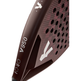 Close-up of the maroon VOLT 950 V23 padel racket by Volt, designed for advanced players. It features a hexagonal grid pattern and a handle with small white logos. Crafted for power and control, its matte surface displays a refined carbon texture.